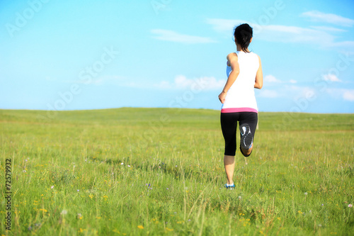 Runner athlete running on seaside green grass