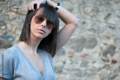 Teenage girl with sun glasses. Rock Wall background