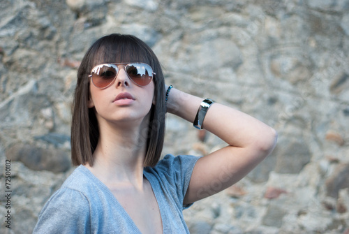 Teenage girl with sun glasses. Rock Wall background