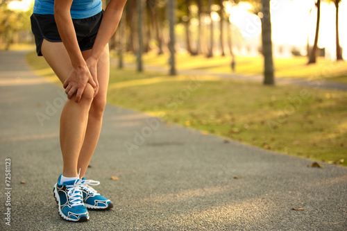 woman runner hold her sports injured knee 