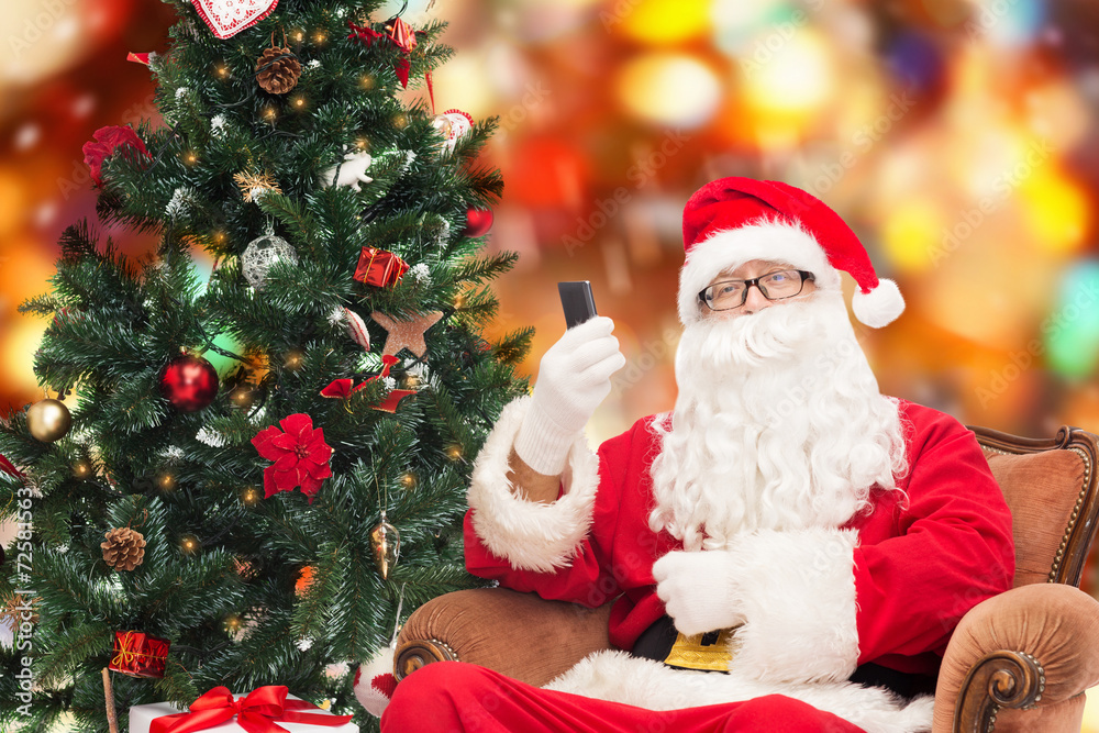 santa claus with smartphone and christmas tree santa claus with smartphone and christmas tree