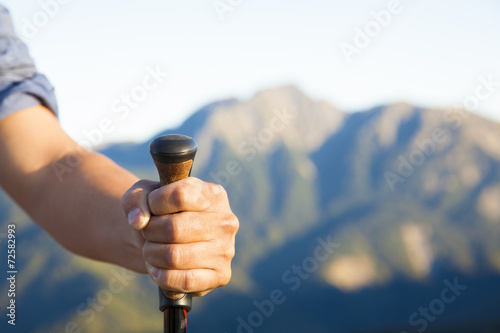 hand holding alpenstock and  mountain peak background photo