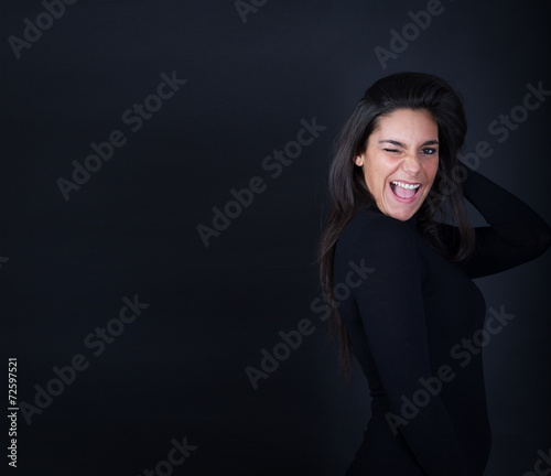 Tableau sur toile girl wink and smile on dark background