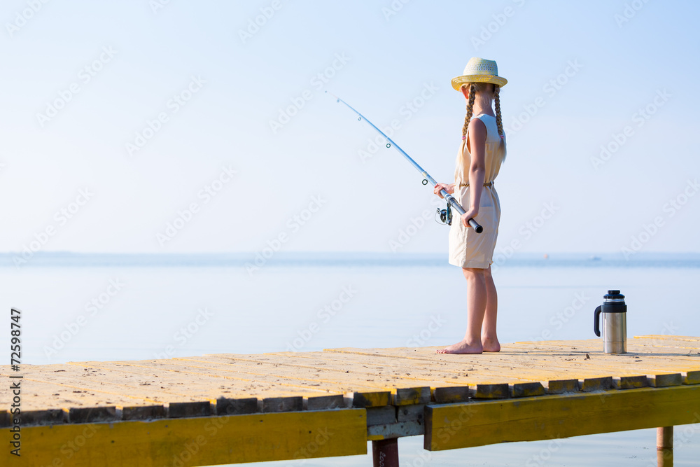 Girl in a dress and a hat with a fishing rod Girl in a dress and a hat with a fishing rod