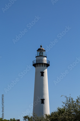 White Brick Lighthouse with Black Iron Hardware Under Blue Skies © dbvirago