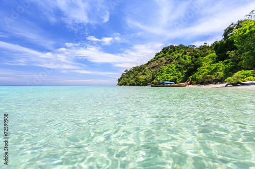 Longtail boat on crystal clear sea at tropical beach