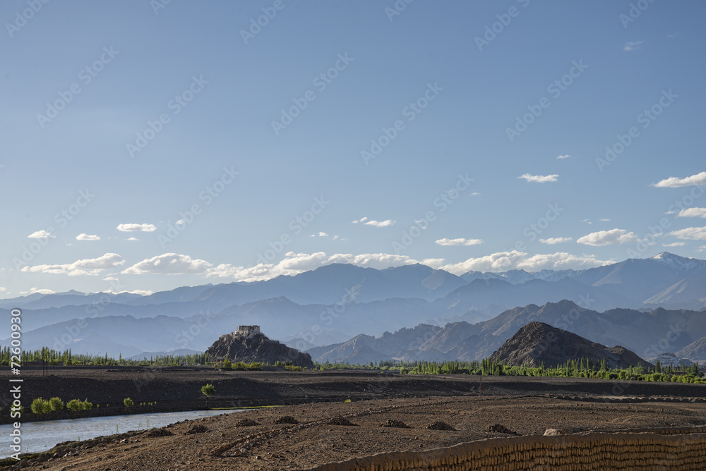 Obraz premium Castle on rock with majestic mountains background