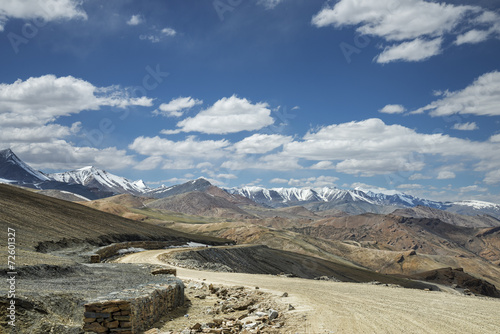 View of curved road among snow capped mountains