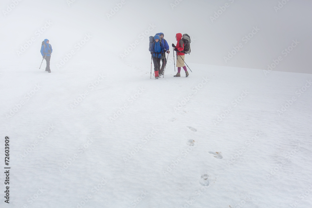 Group of hiker are walking in mist in winter time