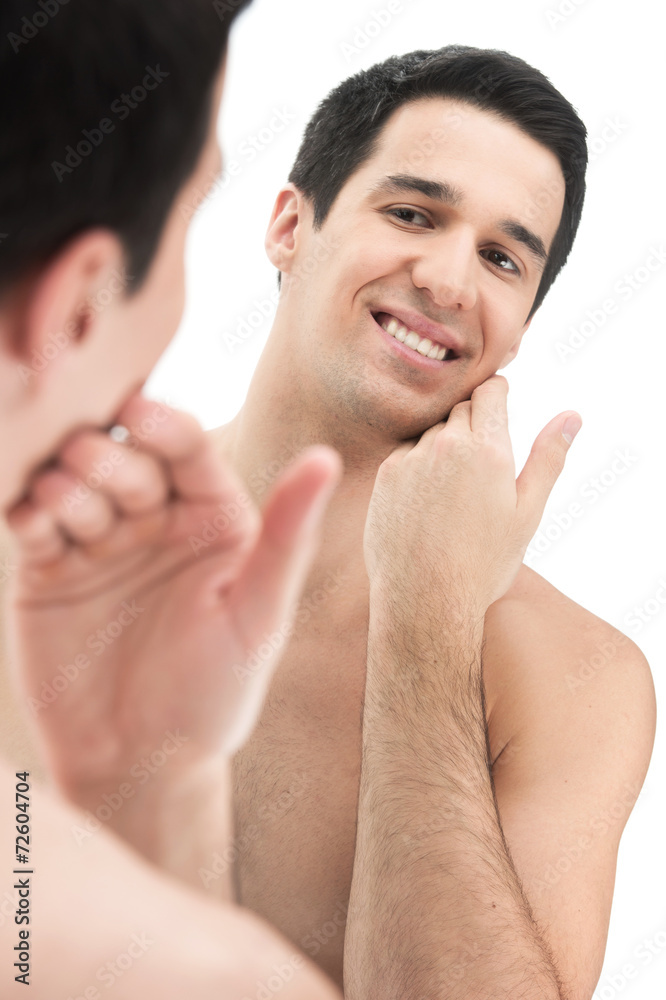 Fototapeta premium Young handsome man touching his smooth face after shaving.
