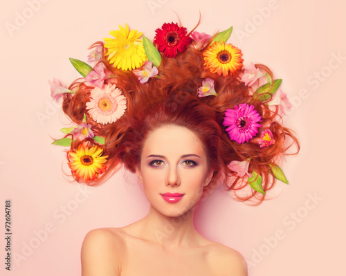 Fototapeta Naklejka Na Ścianę i Meble -  Beautiful redhead girl with flowers on pink background