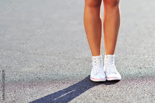Woman legs in sneakers