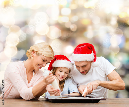 happy family in santa helper hats cooking
