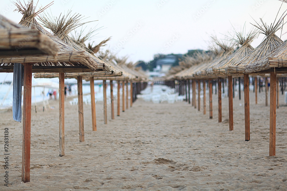 sandy beach sunbeds umbrellas sea