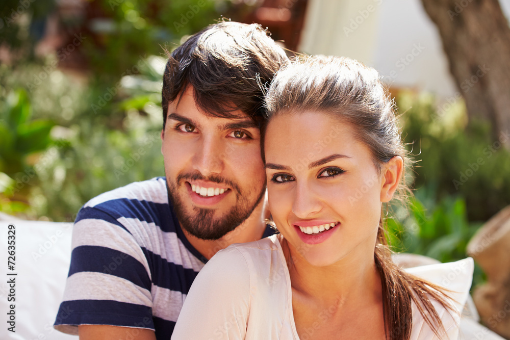Portrait Of Couple Sitting Outdoors In Garden Together