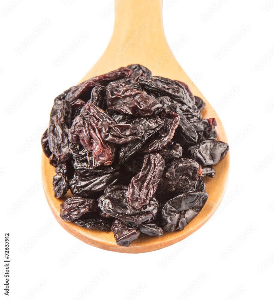 Black raisin on wooden spoon over white background Black raisin on wooden spoon over white background