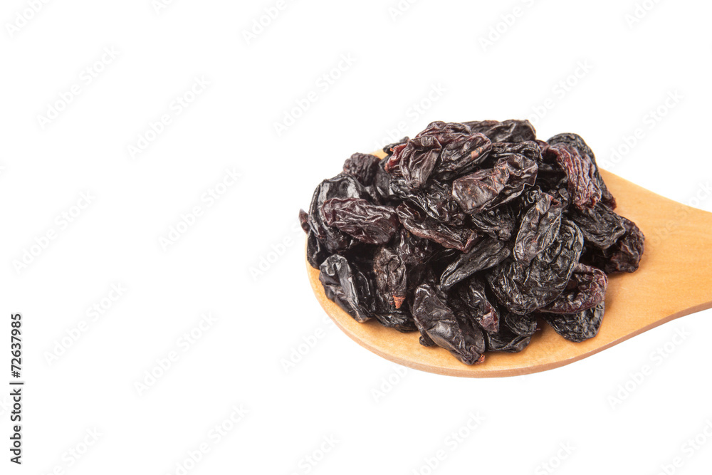 Black raisin on wooden spoon over white background Black raisin on wooden spoon over white background