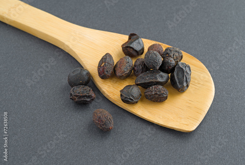 Tableau sur toile Wood spoon filed with saw palmetto berries
