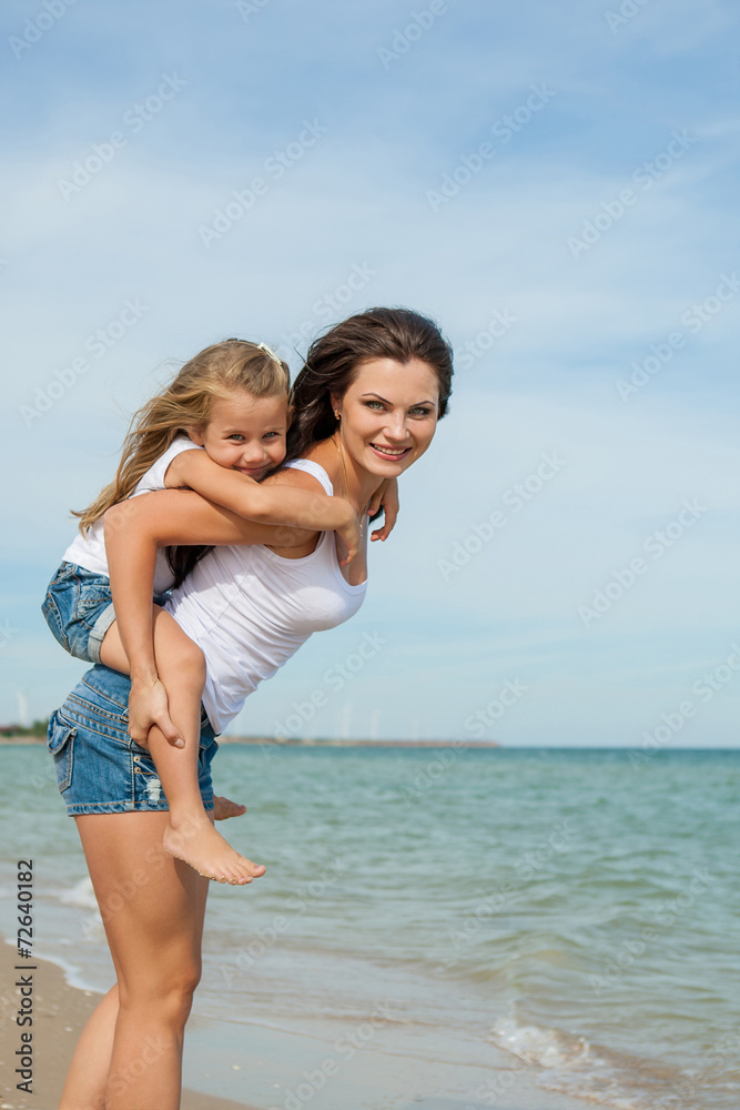 Mother and her daughter  having fun on the beach