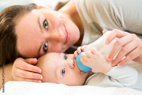 mom feeding baby boy with a milk bottle