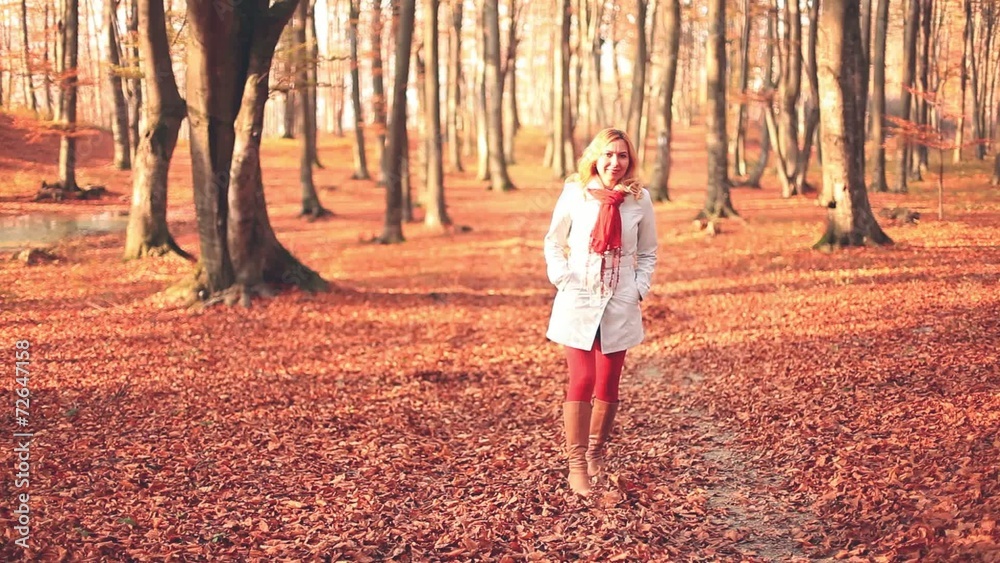 Blonde woman walking through a forest during autumn