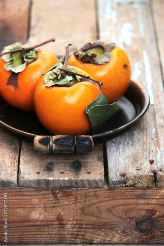 Fresh ripe persimmon on a wooden table