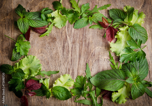 Fresh green salad on the frame of wooden background