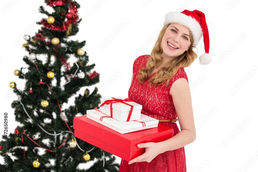 Blonde holding pile of gifts with christmas tree behind her Blonde holding pile of gifts with christmas tree behind her