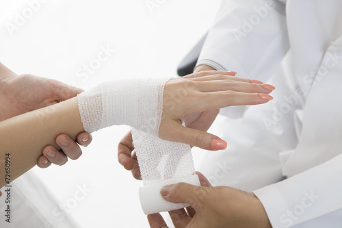 Doctors bandage to women of wrist