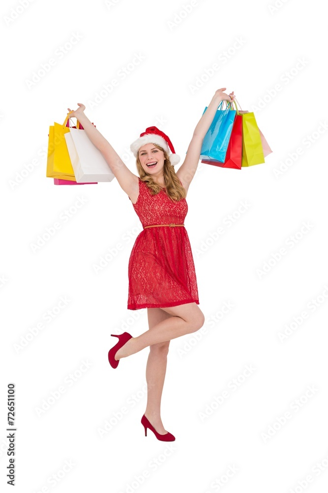 Pretty woman in santa hat holding up shopping bags