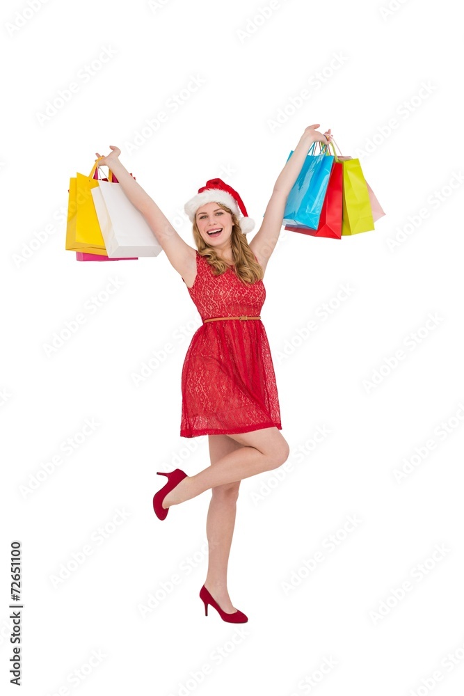 Pretty woman in santa hat holding up shopping bags Pretty woman in santa hat holding up shopping bags