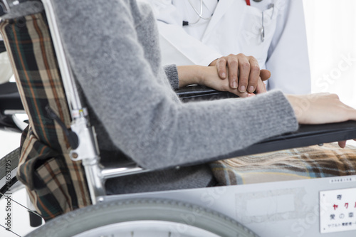 Male doctor to encourage a wheelchair patient