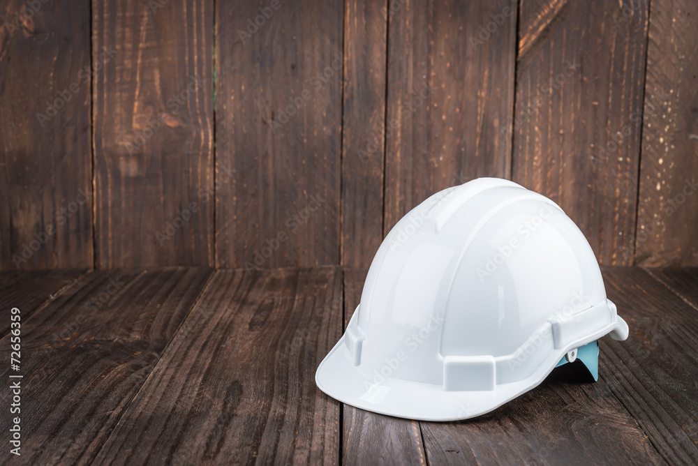 Construction hard hat on wooden background Construction hard hat on wooden background