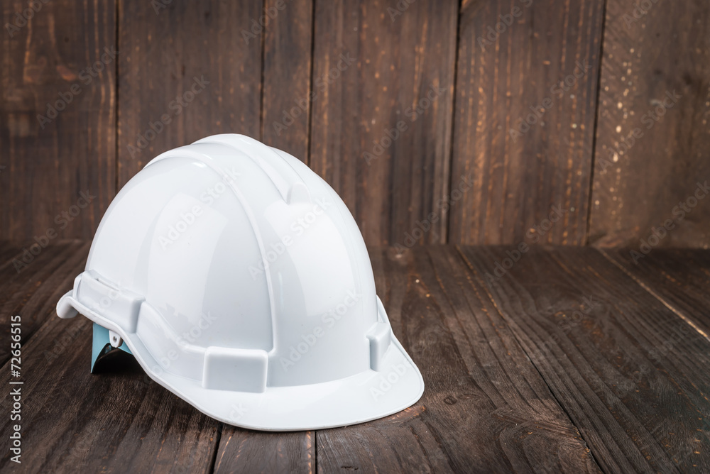 Construction hard hat on wooden background Construction hard hat on wooden background