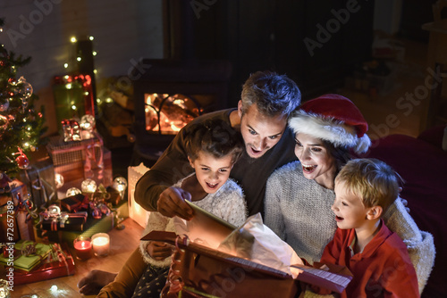 happy family finds a digital tablet in a gift on the Christmas n