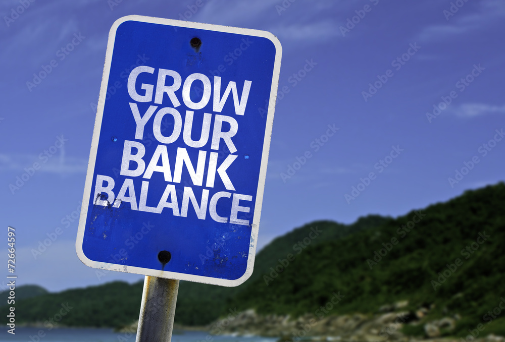 Grow Your Bank Balance sign with a beach on background