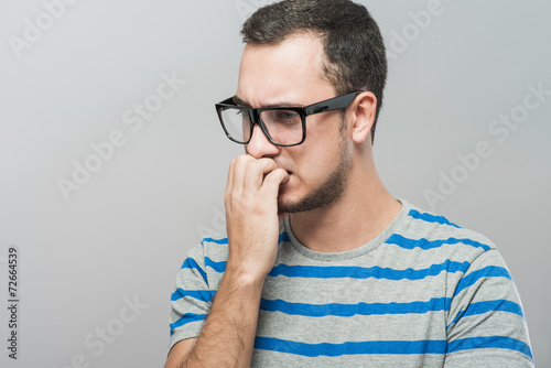 Фотография Closeup portrait of a nerdy young guy with glasses