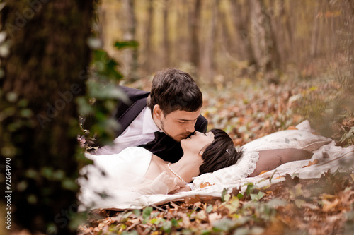 Bride and groom are in the maple leaves on pillow