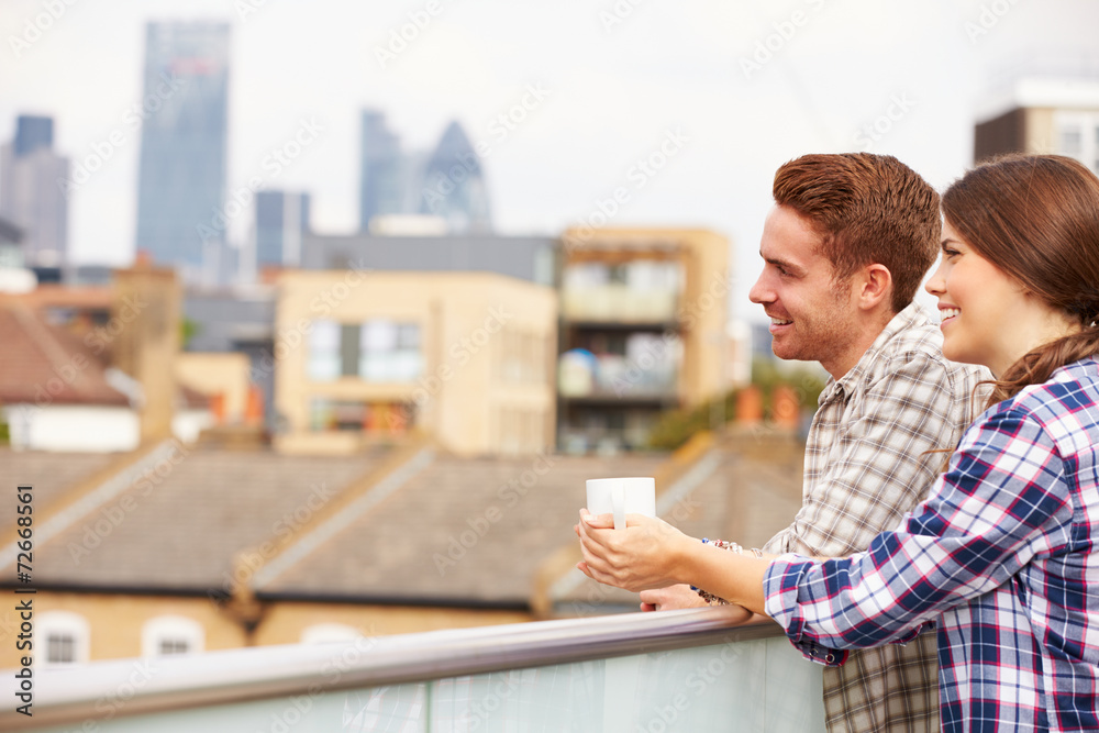 Couple Relaxing Outdoors On Rooftop Garden Drinking Coffee Couple Relaxing Outdoors On Rooftop Garden Drinking Coffee