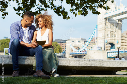 Photography Couple Using Digital Tablet With Tower Bridge In Background