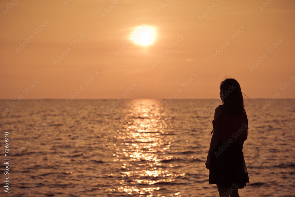Beautiful young woman on sea in twilight