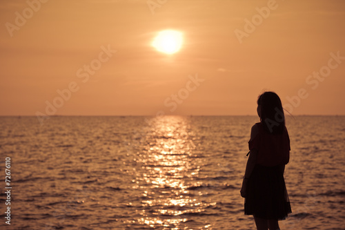 Beautiful young woman on sea in twilight