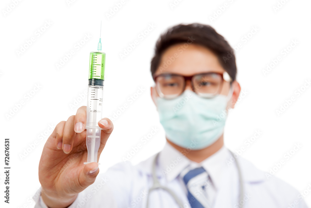 Asian male doctor wear mask look at syringe Asian male doctor wear mask look at syringe
