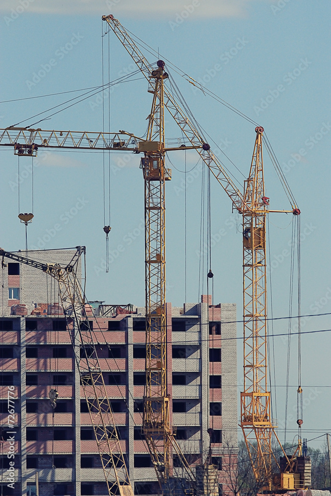 cranes building a house