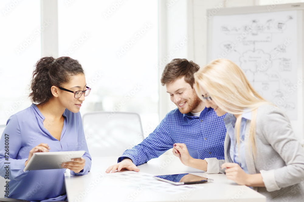 smiling team with table pc and papers working smiling team with table pc and papers working