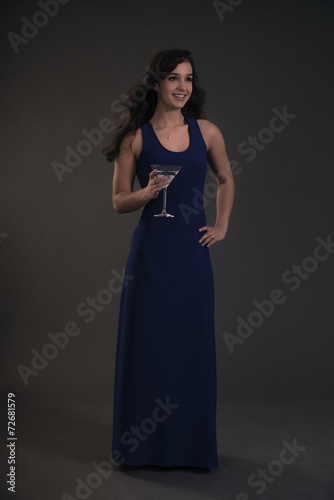 Pretty brunette teenage girl holding cocktail glass wearing blue