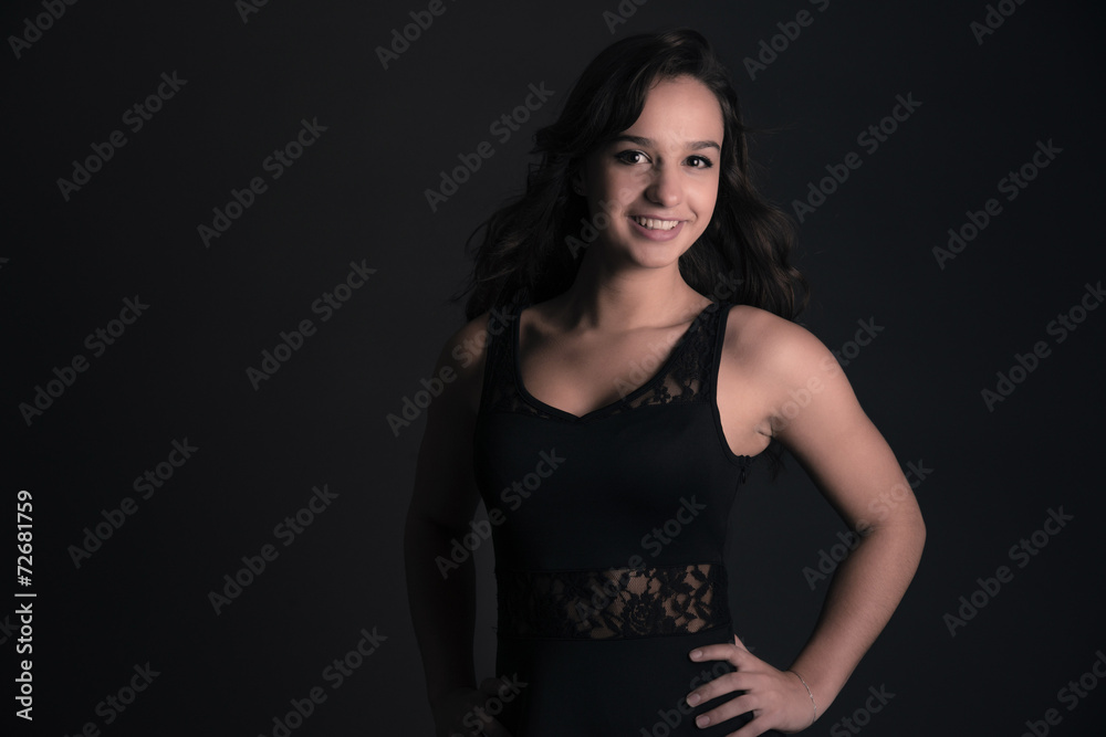 Smiling cute brunette teenage girl wearing black dress. Studio f Smiling cute brunette teenage girl wearing black dress. Studio f