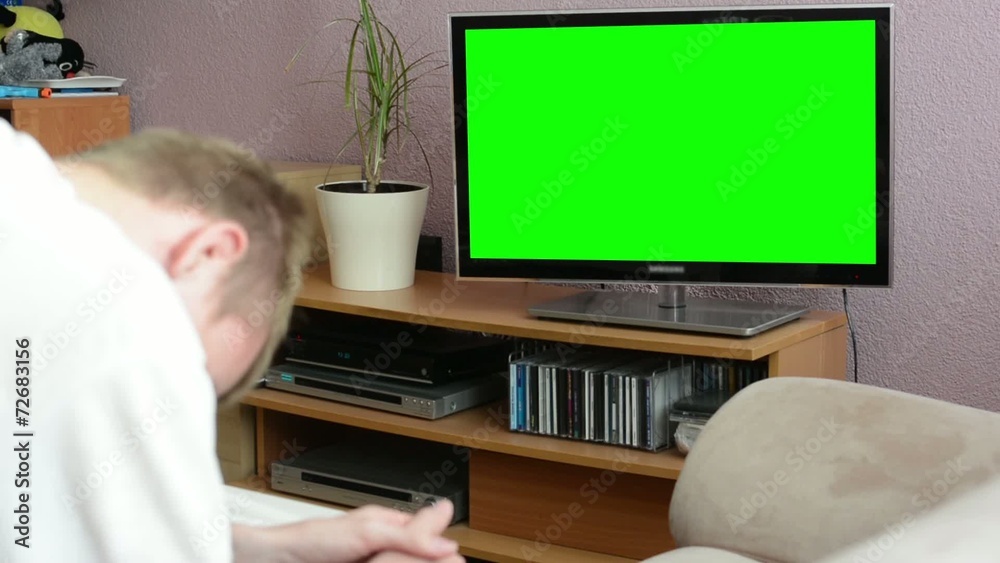 Man watches TV(television) - green screen - man laughs Man watches TV(television) - green screen - man laughs