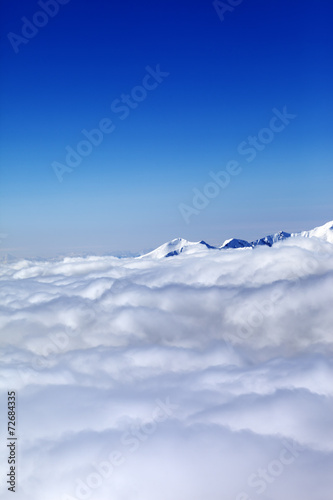 Mountains under clouds and clear blue sky