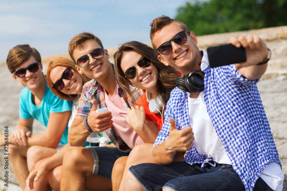 group of smiling friends with smartphone outdoors group of smiling friends with smartphone outdoors